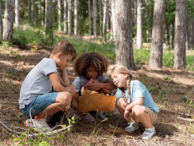 Деца от лагера Лъки Банско Кидс Камп разучават карта по време на разходка в планината.