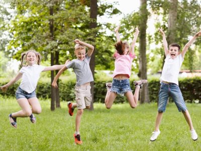 Щастливи деца скачат на поляна