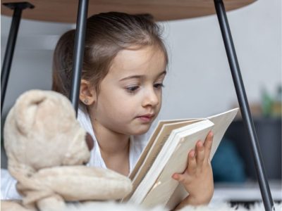 Малко момиче заинтересовано чете книга