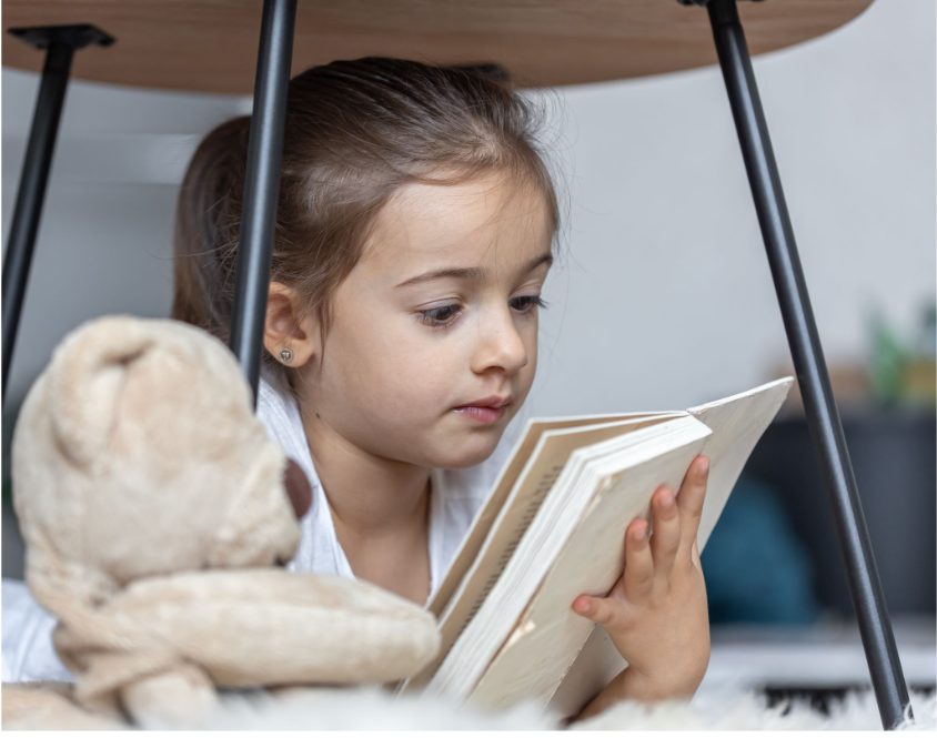 Малко момиче заинтересовано чете книга